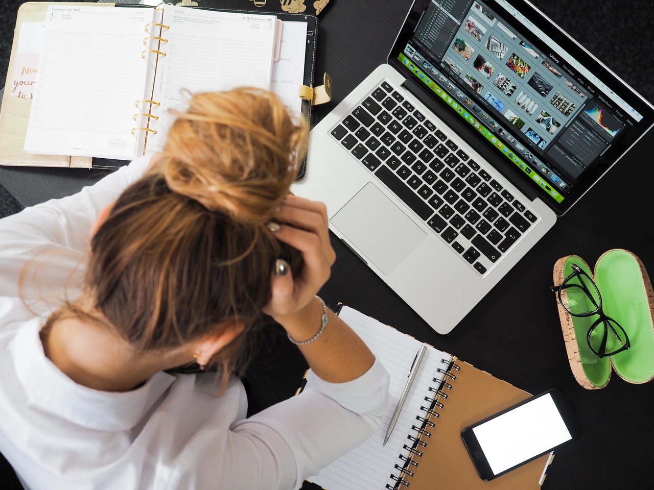 Stressed woman with notebooks and laptop around her